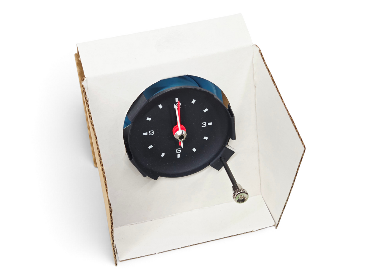 Send it Auto Parts 1977 Corvette C3 quartz clock with black face, white markers, and red hands in original packaging.