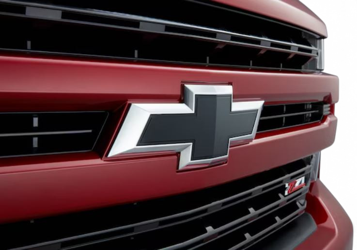 Send it Auto Parts black front bowtie emblem installed on a red Chevrolet Silverado HD truck grille.