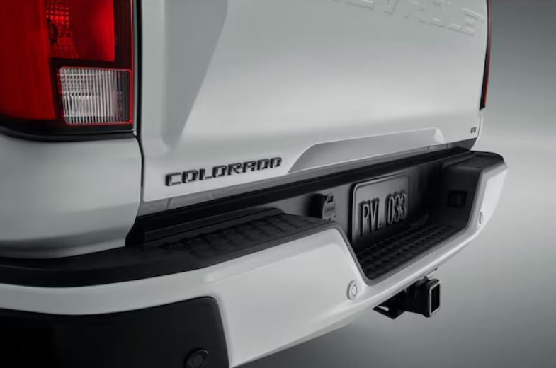Send it Auto Parts black Colorado emblem installed on the white tailgate of a Chevrolet truck