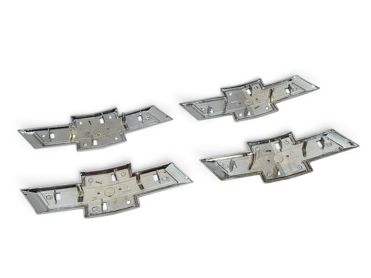Send it Auto Parts lot of four genuine OEM gold Chevrolet Silverado 1500 front grille bowtie emblems, rear view.
