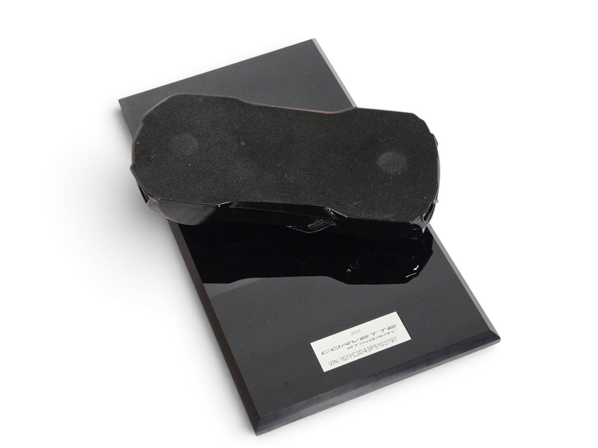 Send it Auto Parts 1:18 scale black 2023 Corvette C8 speedshape model on a display base, top-down view.