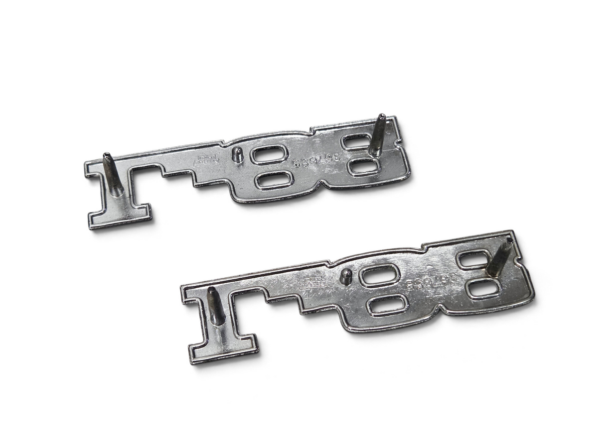 Pair of genuine Send it Auto Parts OEM GM L82 hood emblems for 1975-1979 Corvette C3, showing back side with pins.