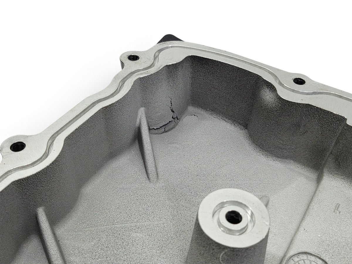 Send it Auto Parts damaged OEM GM supercharger cover lid for Chevy Camaro ZL1 showing structural cracks in metal