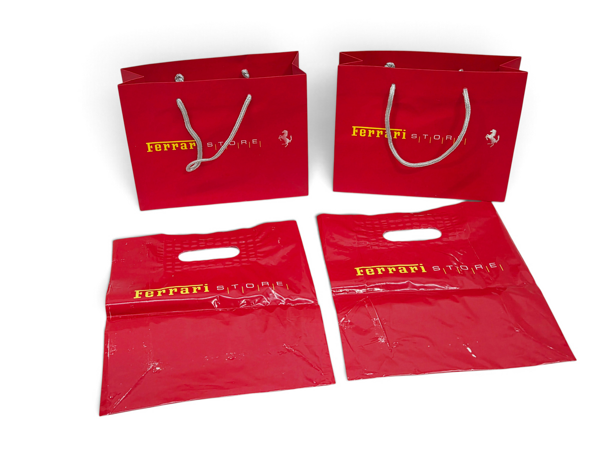 Send it Auto Parts Ferrari Store shopping bag lot with two red paper bags and two red plastic bags with logos.