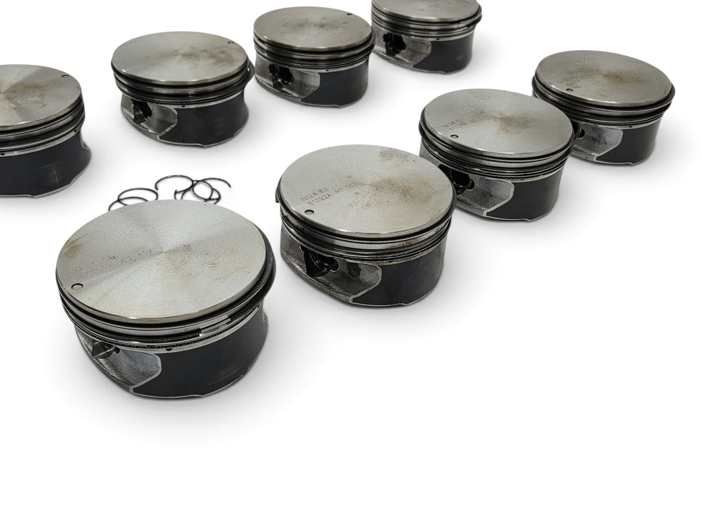 Send it Auto Parts set of eight OEM GM 6.2L LS3 L92 L99 flat top pistons with pins and clips on a white background