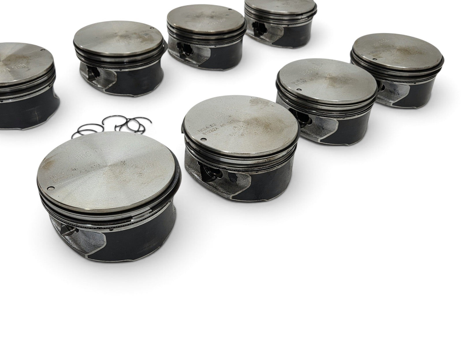 Send it Auto Parts set of eight OEM GM 6.2L LS3 L92 L99 flat top pistons with pins and clips on a white background