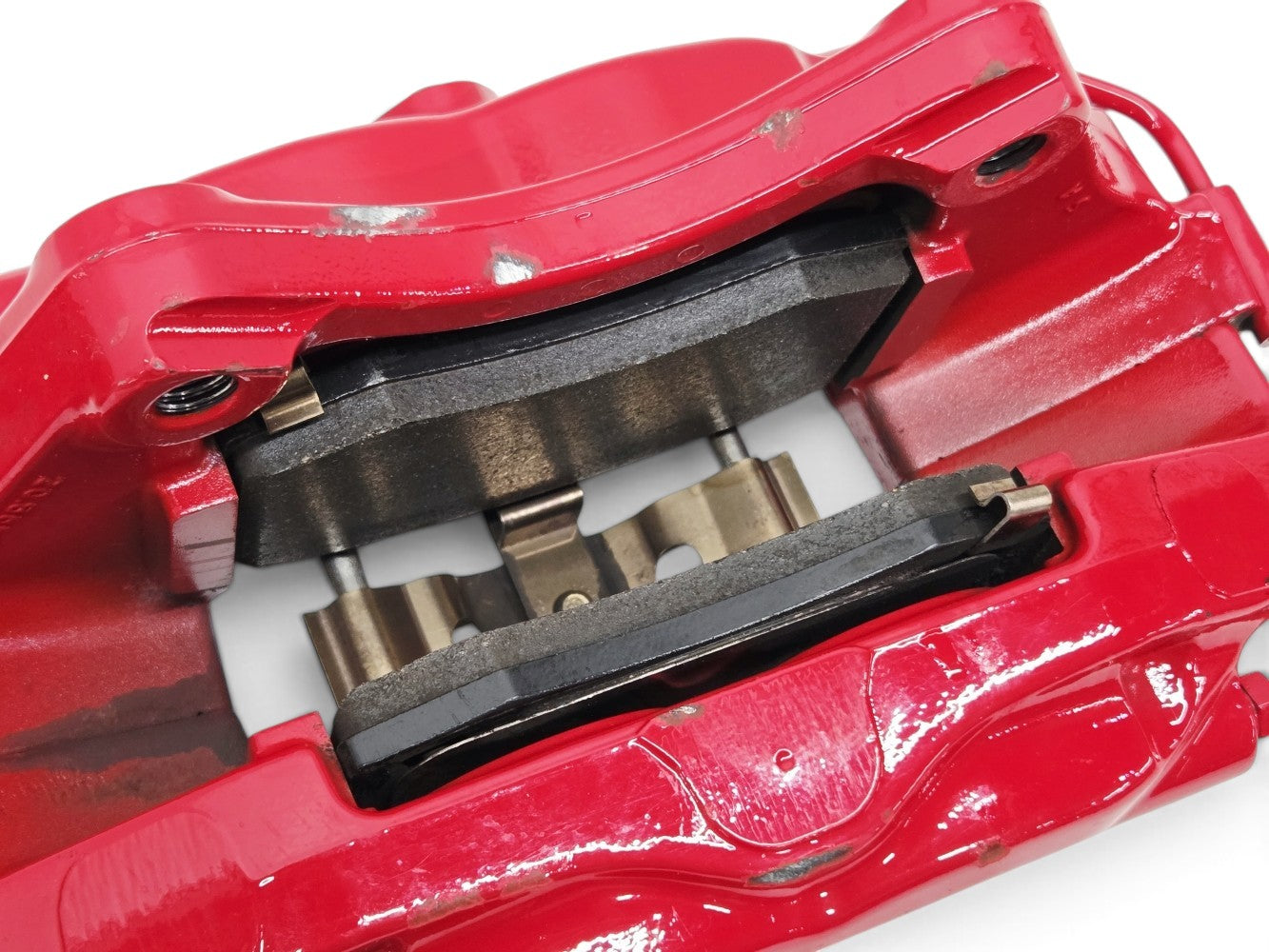 Send it Auto Parts OEM red Brembo rear brake calipers with pads for Chevrolet Camaro ZL1, showing minor surface wear.